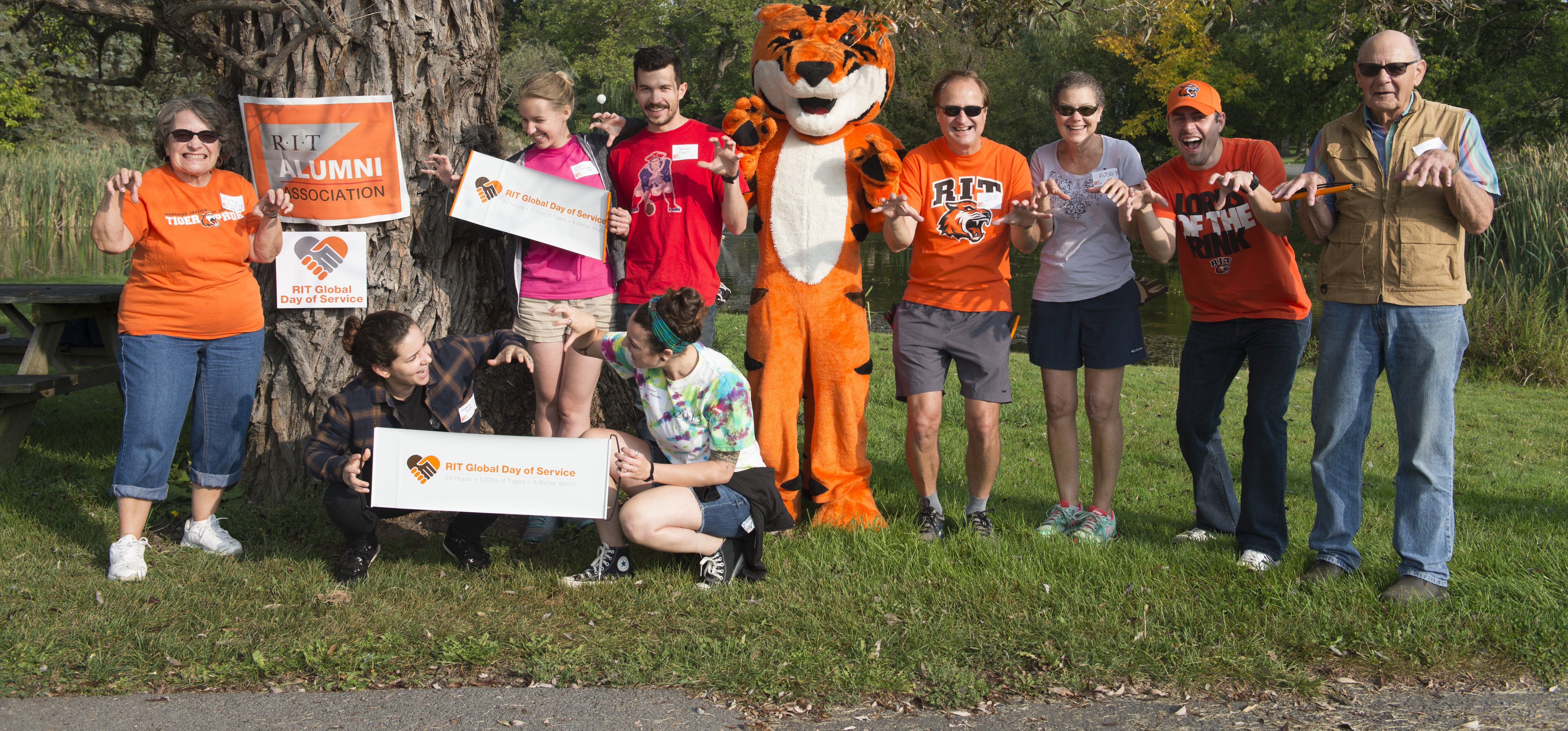 Group of volunteers posing with Richie the RIT Mascot 