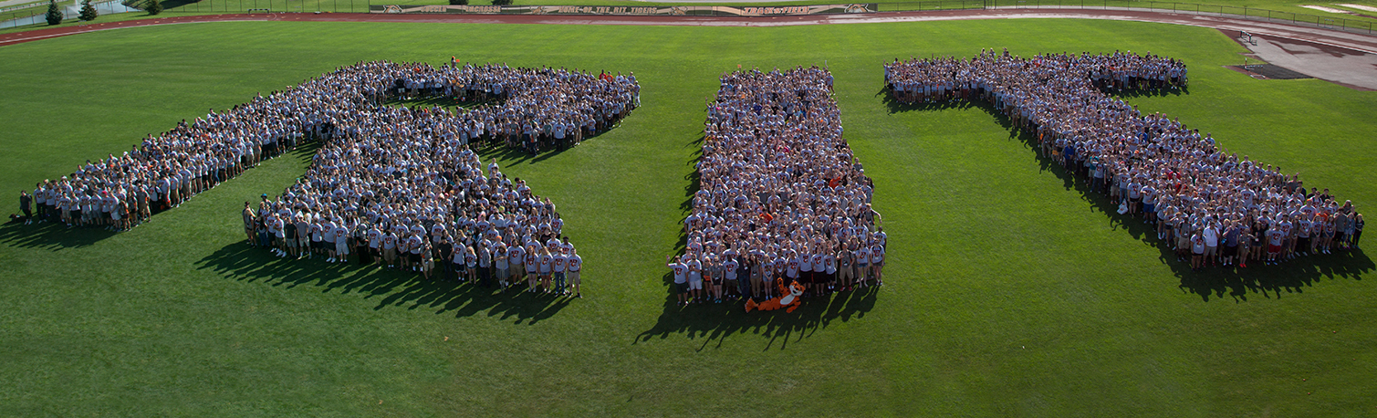 RIT made up of people standing in a grassy field