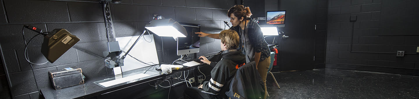 Two people reviewing data on a computer in a dark room