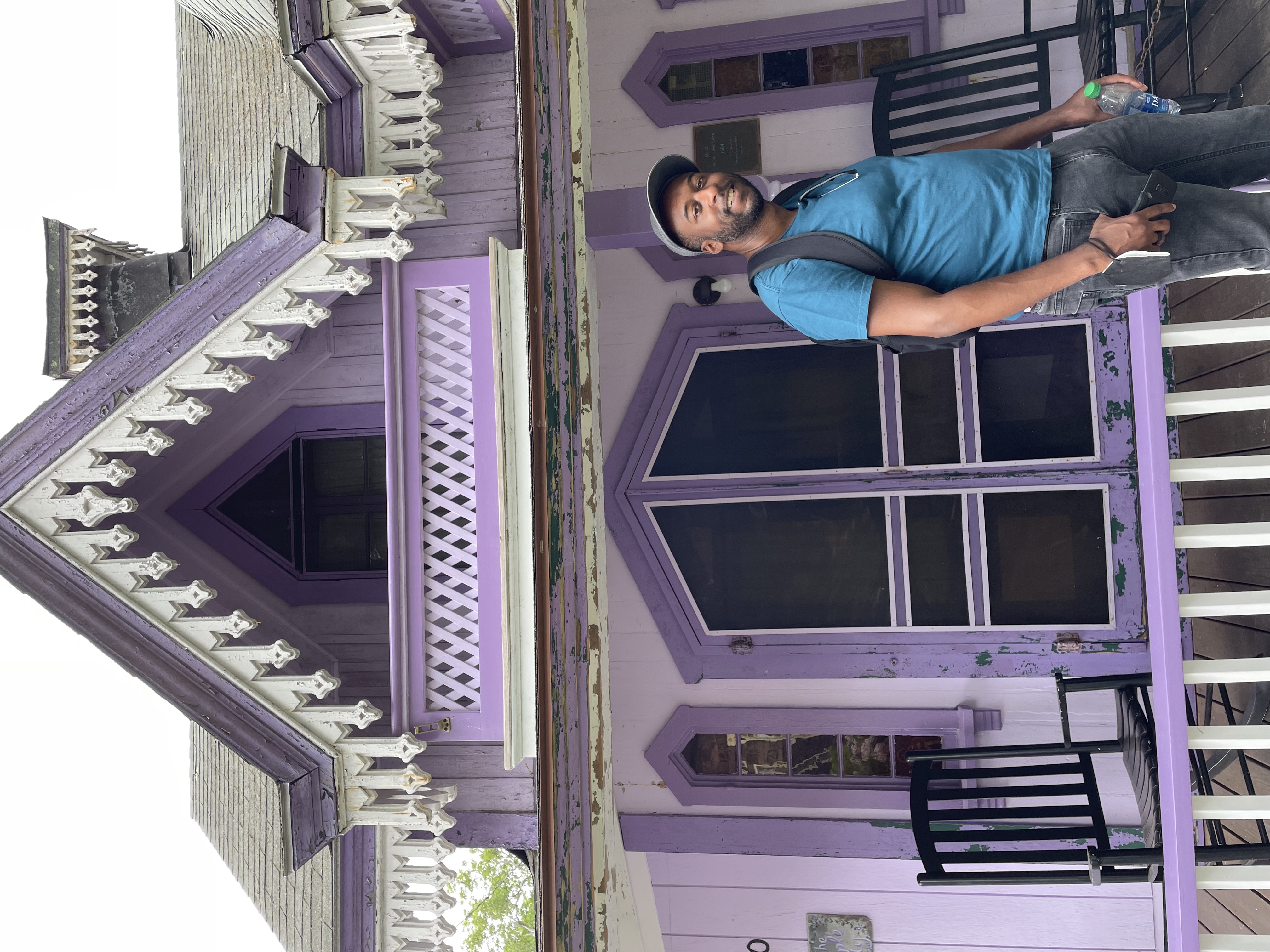 Taj standing in front of purple painted building