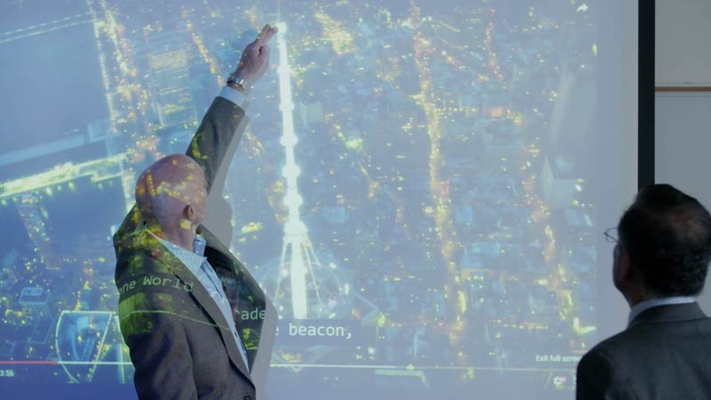 Man pointing to a map on a projector