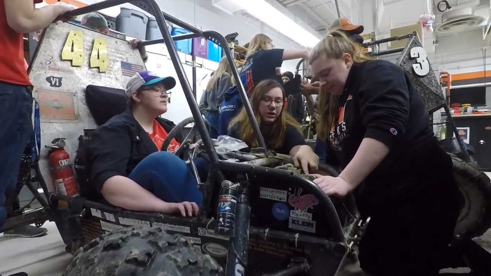 A group of students working on a small vehicle