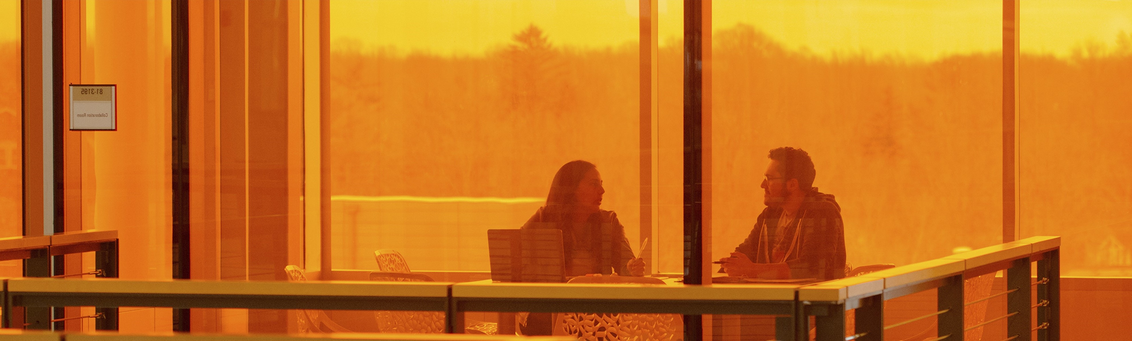 two people meeting behind orange glass