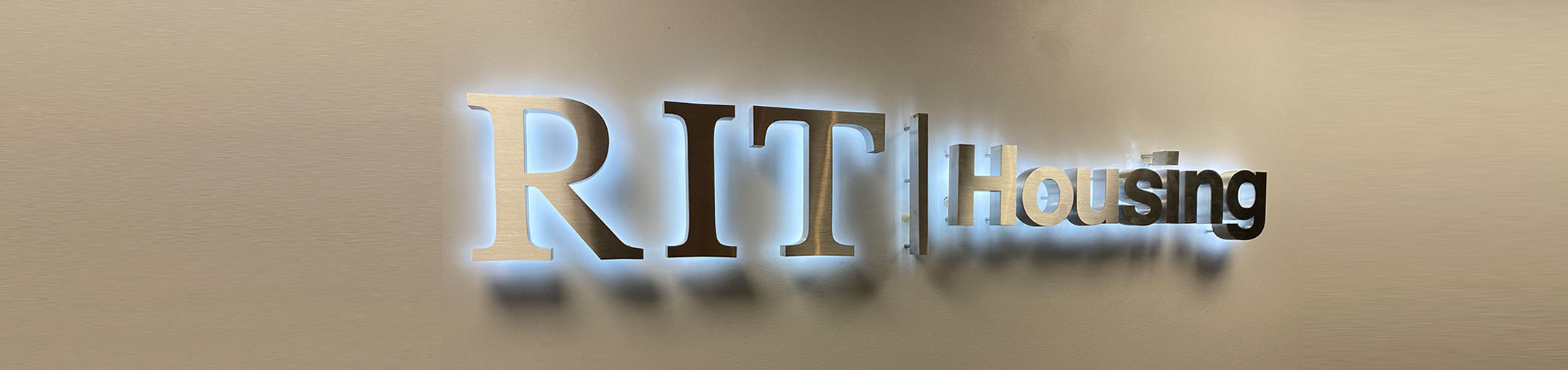Illuminated RIT Housing Logo on a wall