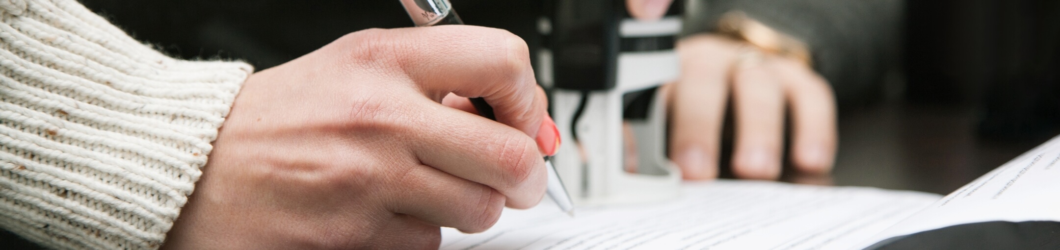 A close up of a person signing a document.
