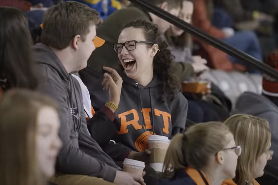 Students laughing at an RIT hockey game