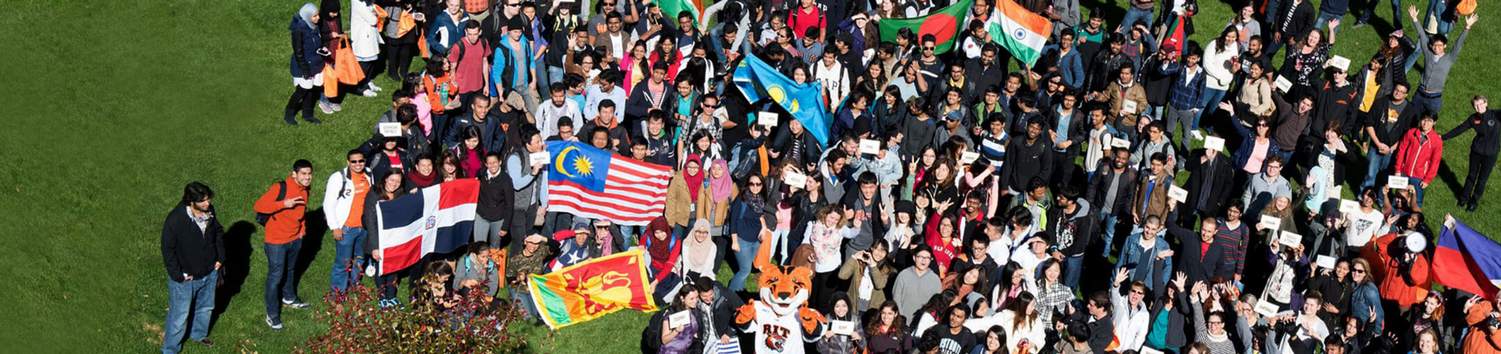 A group of RIT international students holding the flags of various nations.