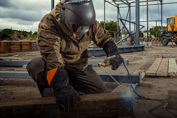 Man welding at a construction site.