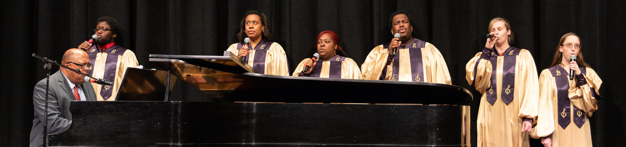 RIT's Gospel ensemble, performing on stage with Wardell Lewis playing the piano.