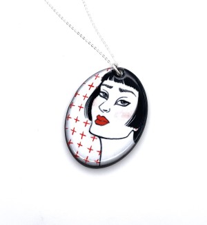 hand illustrated Ceramic necklace with small red addition signs and a black line drawing of a woman's portrait with red details.