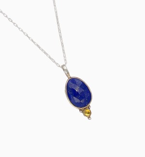 a pendant with a deep blue faceted lapis lazuli with golden flecks. Bezel set in Sterling and accentuated with a regal pop of color compliments of a golden citrine.