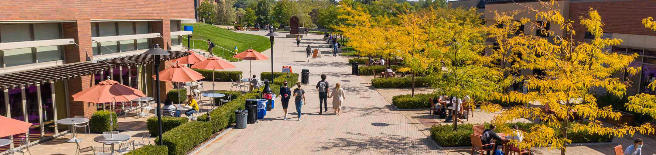 Aerial view of the R I T campus, showing students walking through Global Village on a Fall day.