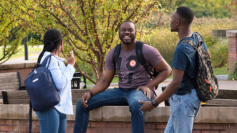 Three students talking and laughing outside
