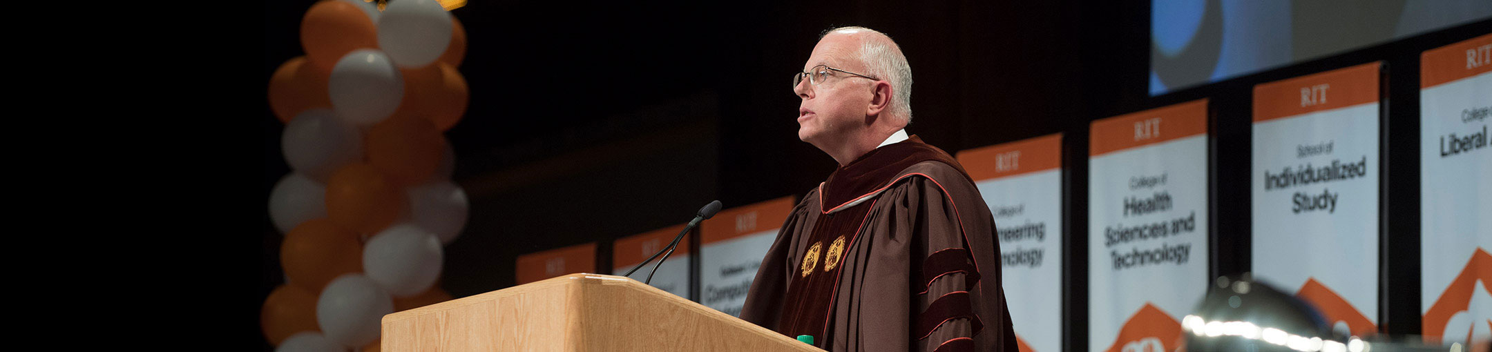 President Munson addressing a group at a graduation ceremony