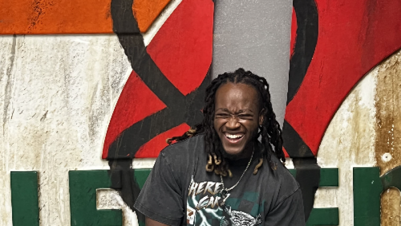 Joshua Michaels standing in front of 7-Eleven sign smiling