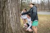 3 students are showing inspecting a maple tree for a soft spot to tap.