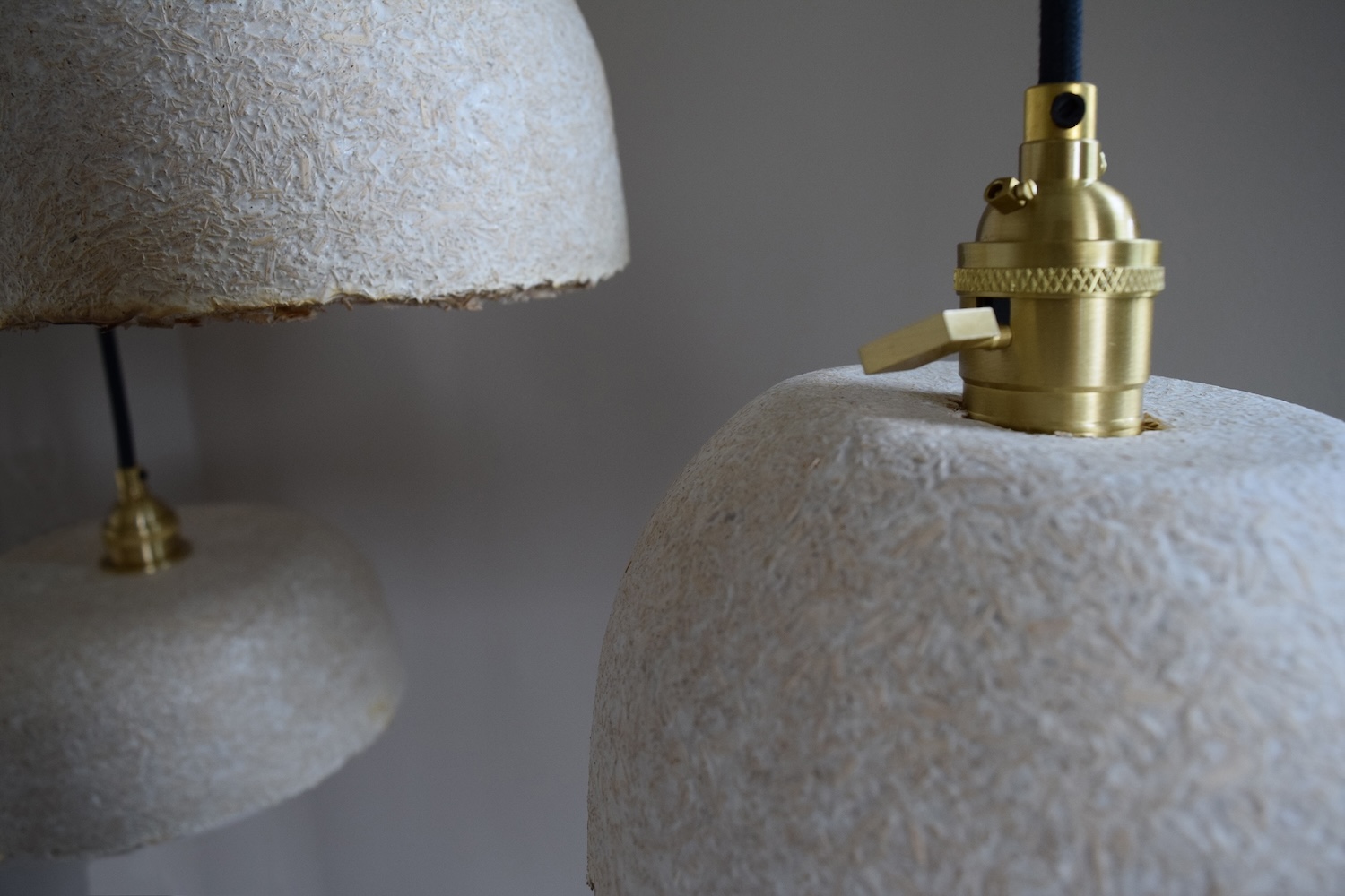 a close up of three pendant lamps with a textured surface.
