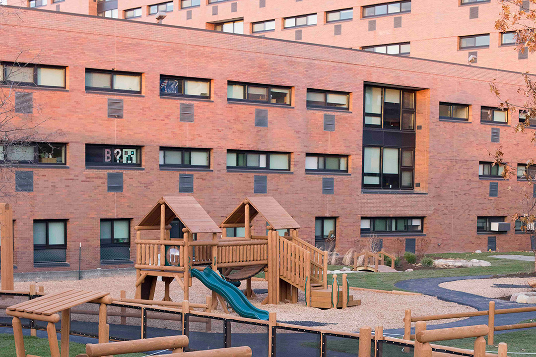 brick building with wooden playground in foreground.