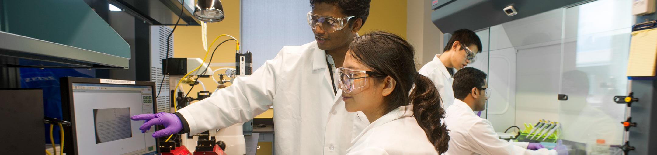 Four RIT student researchers working in a lab.