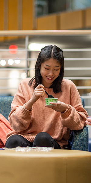 Student eating ice cream in hall