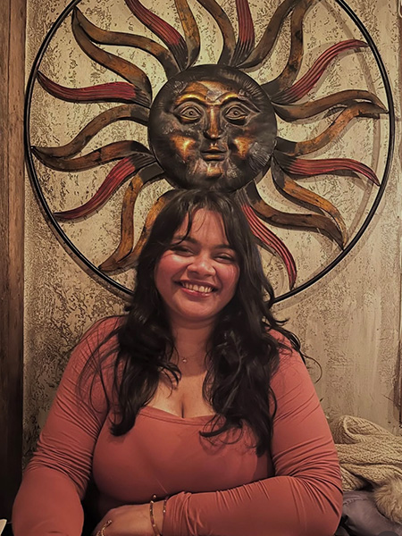 Photo of a student with a sun dial behind her