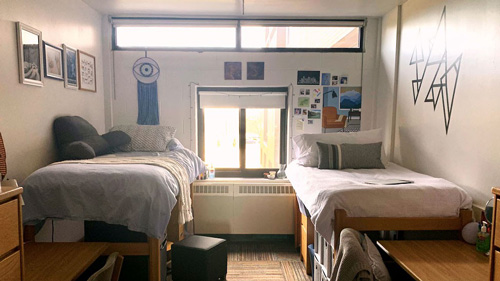 two beds in a dorm room with decorations