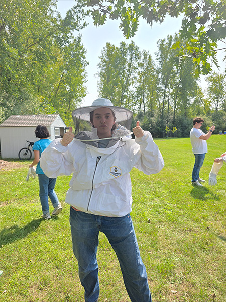 student in a beekeeper outfit