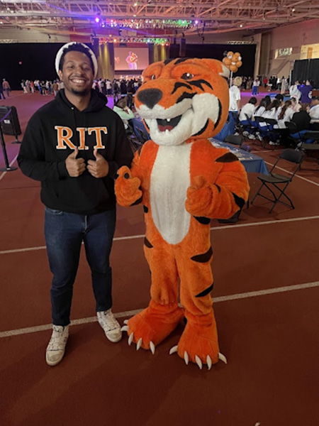 Student posing with Ritchie the Tiger