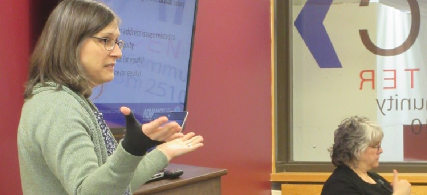 presenter standing in front of a wall mounted tv