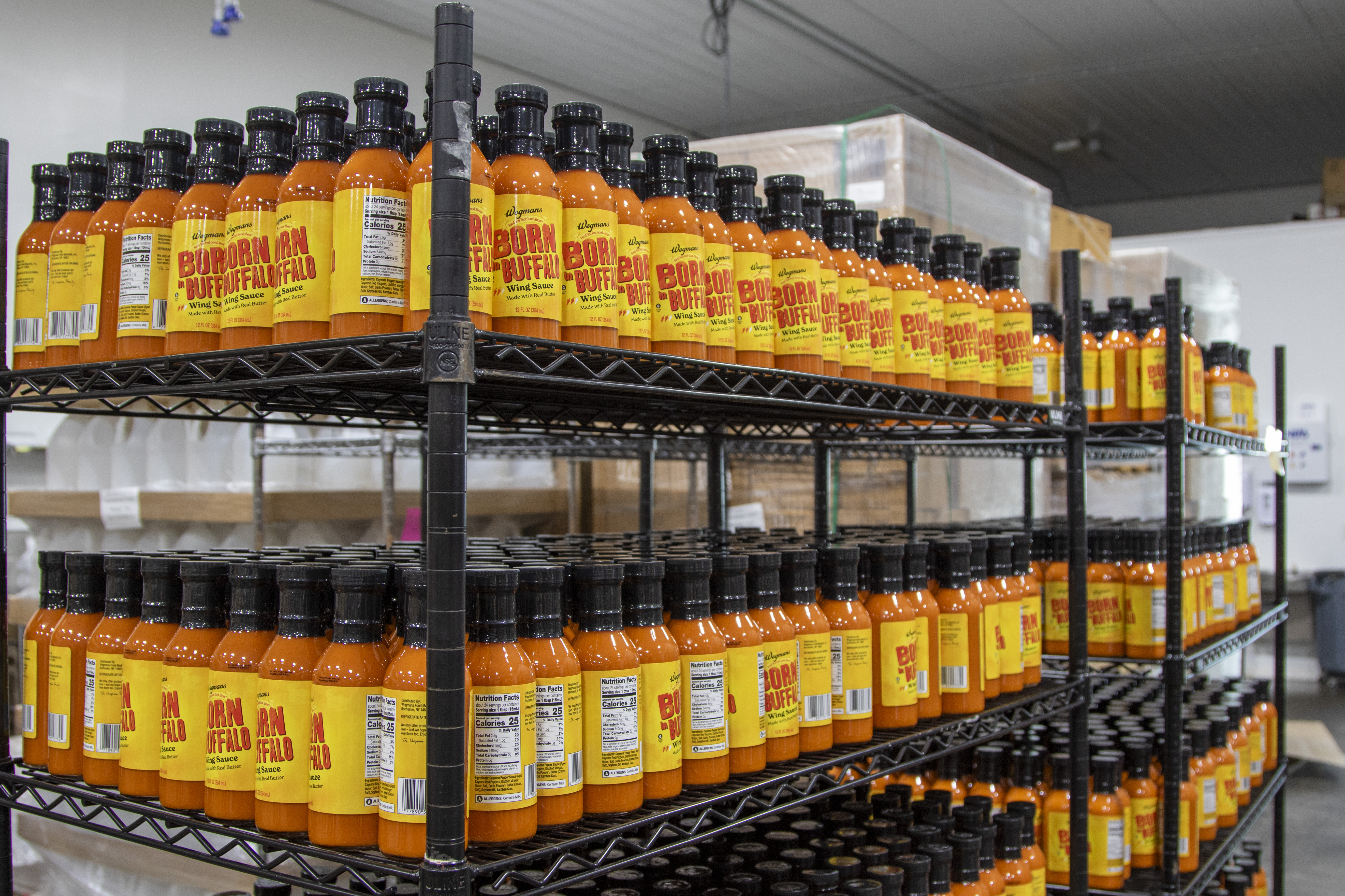 stacks of bottles of hot sauce on black wire shelves