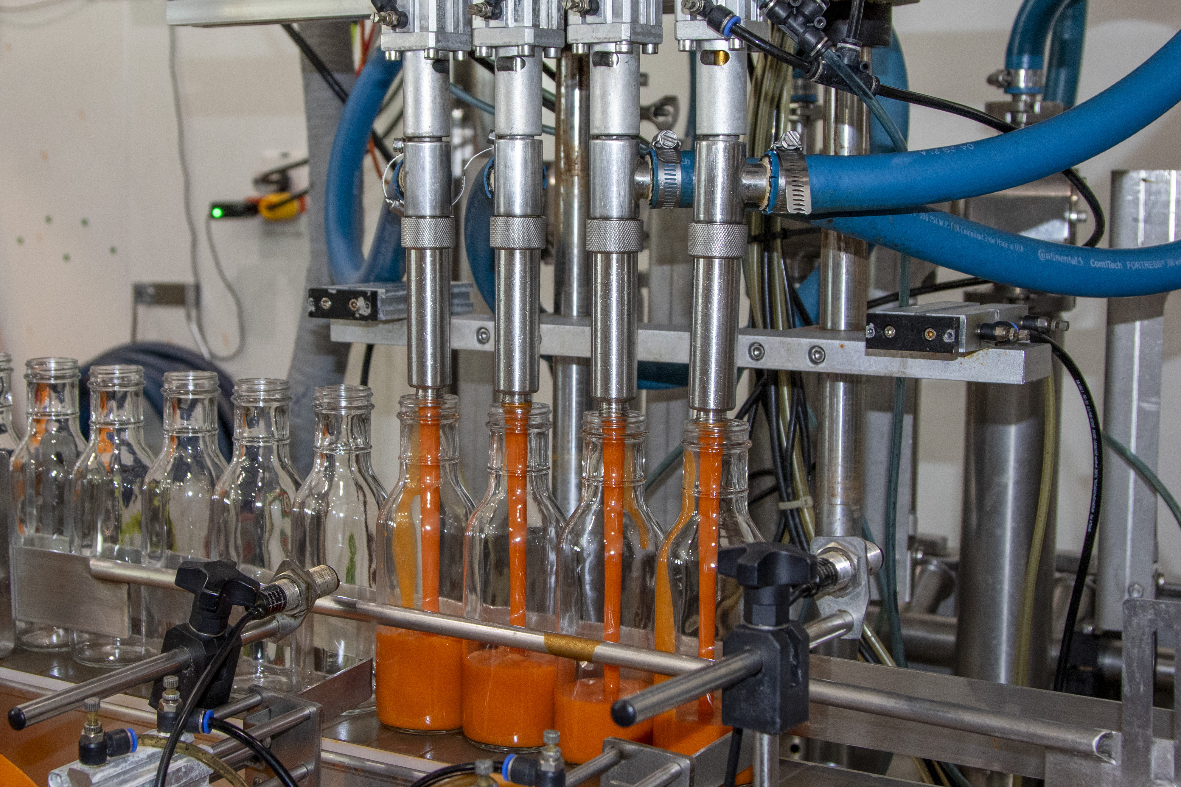 bottles being filled with hot sauce in an automated system