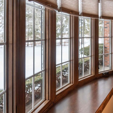 row of windows inside a living room looking out with dark wood trim