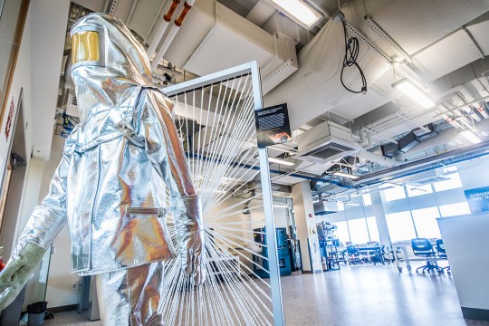 Silver high temperature protective body suit in a lab.