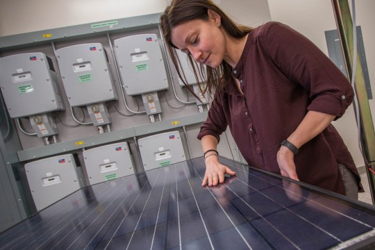 Woman with her hands on a photovoltaic panel.
