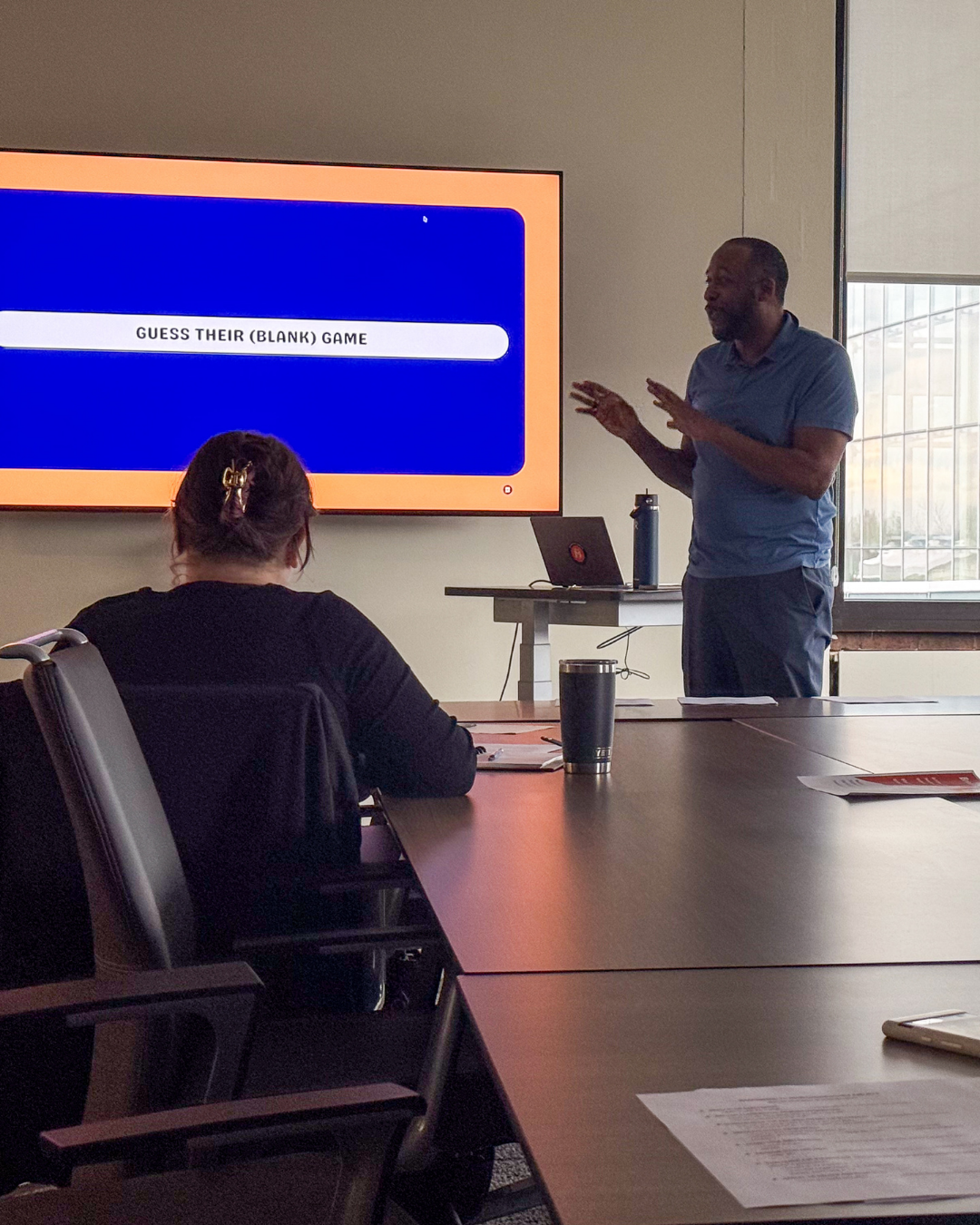Photo of man presenting infront of a tv screen