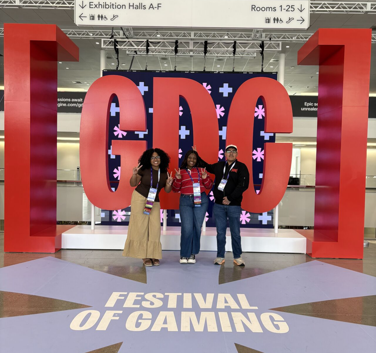 Thr people standign in front of large CDC letters