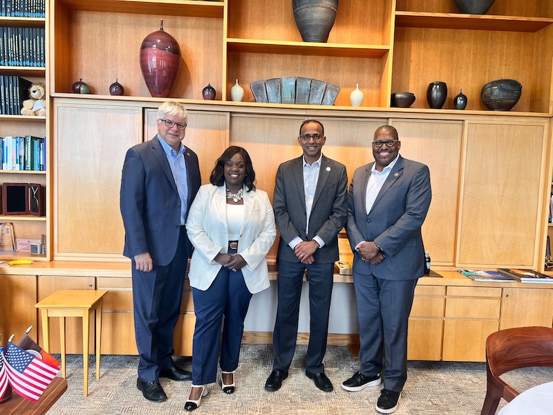 Group of 4 people in front of a bookcase