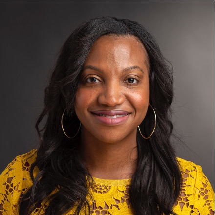 Women's headshot with a yellow shirt and long hair