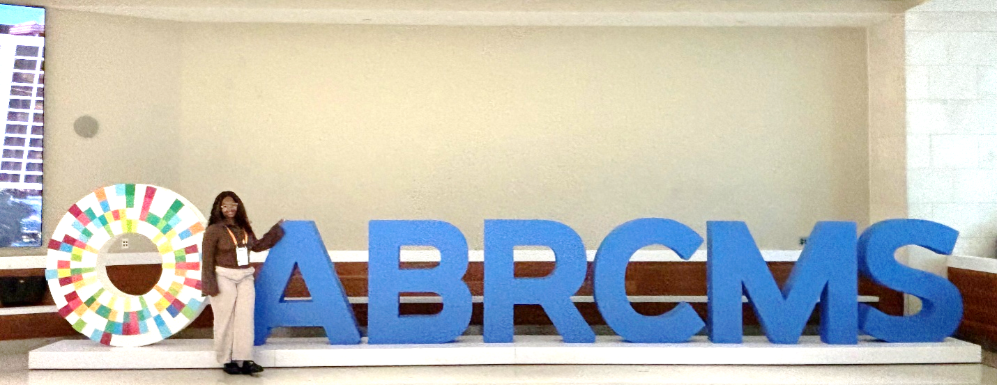 Women posing with a large letter sign with the letters: ABRCMS