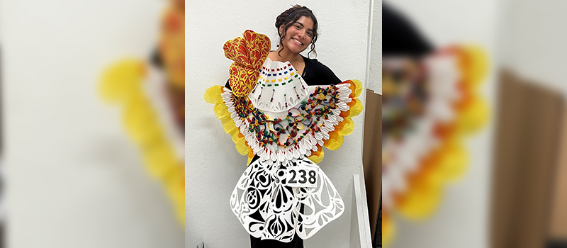 female student standing with fashion design