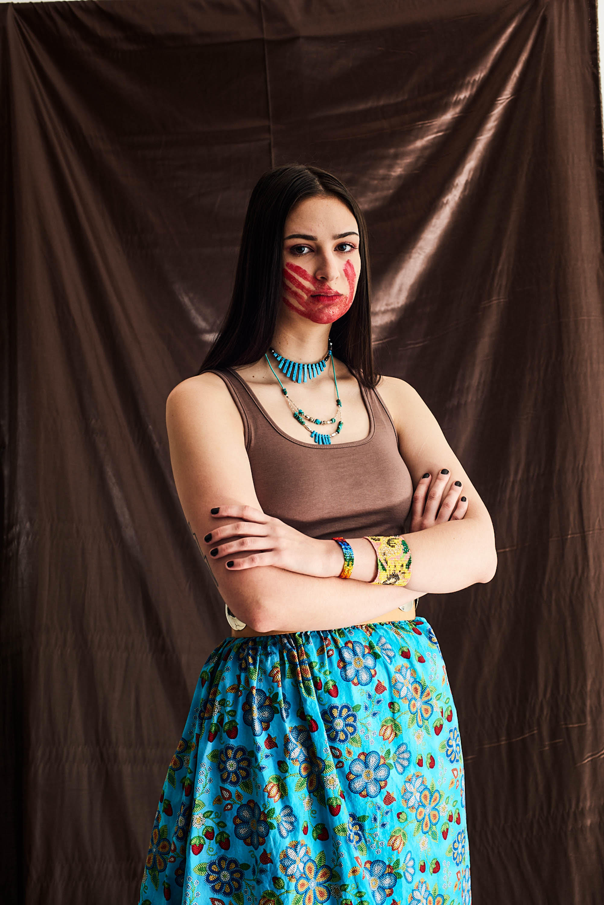 woman standing with arms crossed and red hand print on face