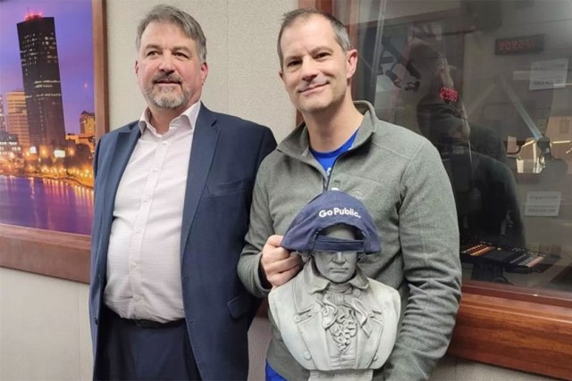 two people standing next to each other, with one holding a bust of Beethoven.