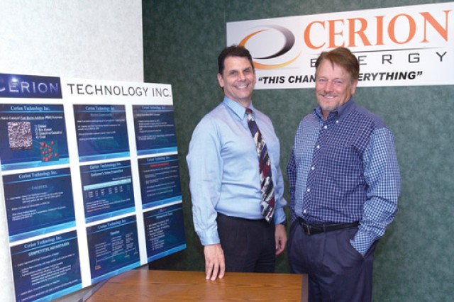 Alumni and person posing by "Cerion Energy" displays