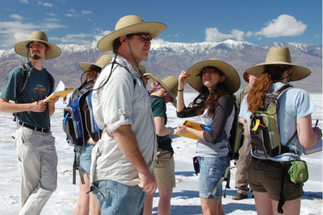 Students taking notes near mountains
