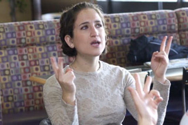 Person speaking with Sign Language in front of couches