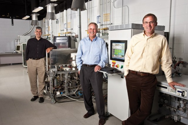 People posing by machines