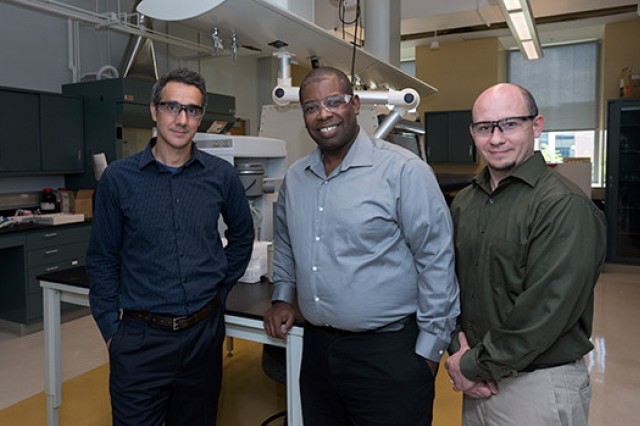 Three people posing in laboratory