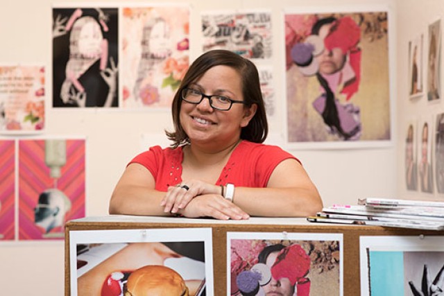 woman posing with prints of her photography.