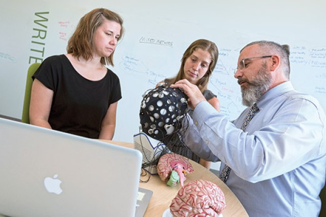 People looking at signal device