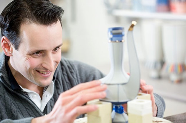 Person looking at a sculpture intently.